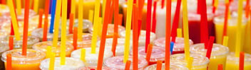 Closeup of many plastic straws in soft drink cups